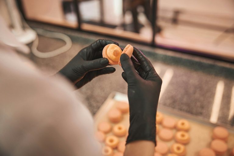 Chef y su equipo trabajando en una cocina profesional, preparando platos. El uso de guantes es muy importante